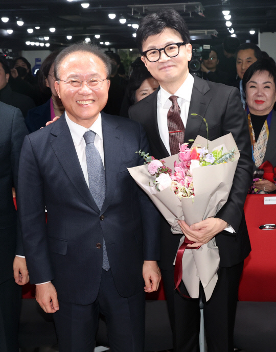 한동훈 국민의힘  비상대책위원장이 26일 여의도 당사에서 열린 취임식에서 꽃다발을 들고 윤재옥 원내대표(왼쪽)와 나란히 서있다.<연합뉴스>